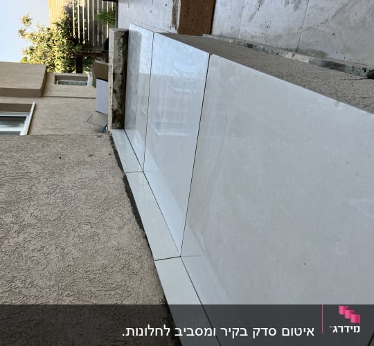 אריחים לבנים מונחים על משטח בטון לאיטום